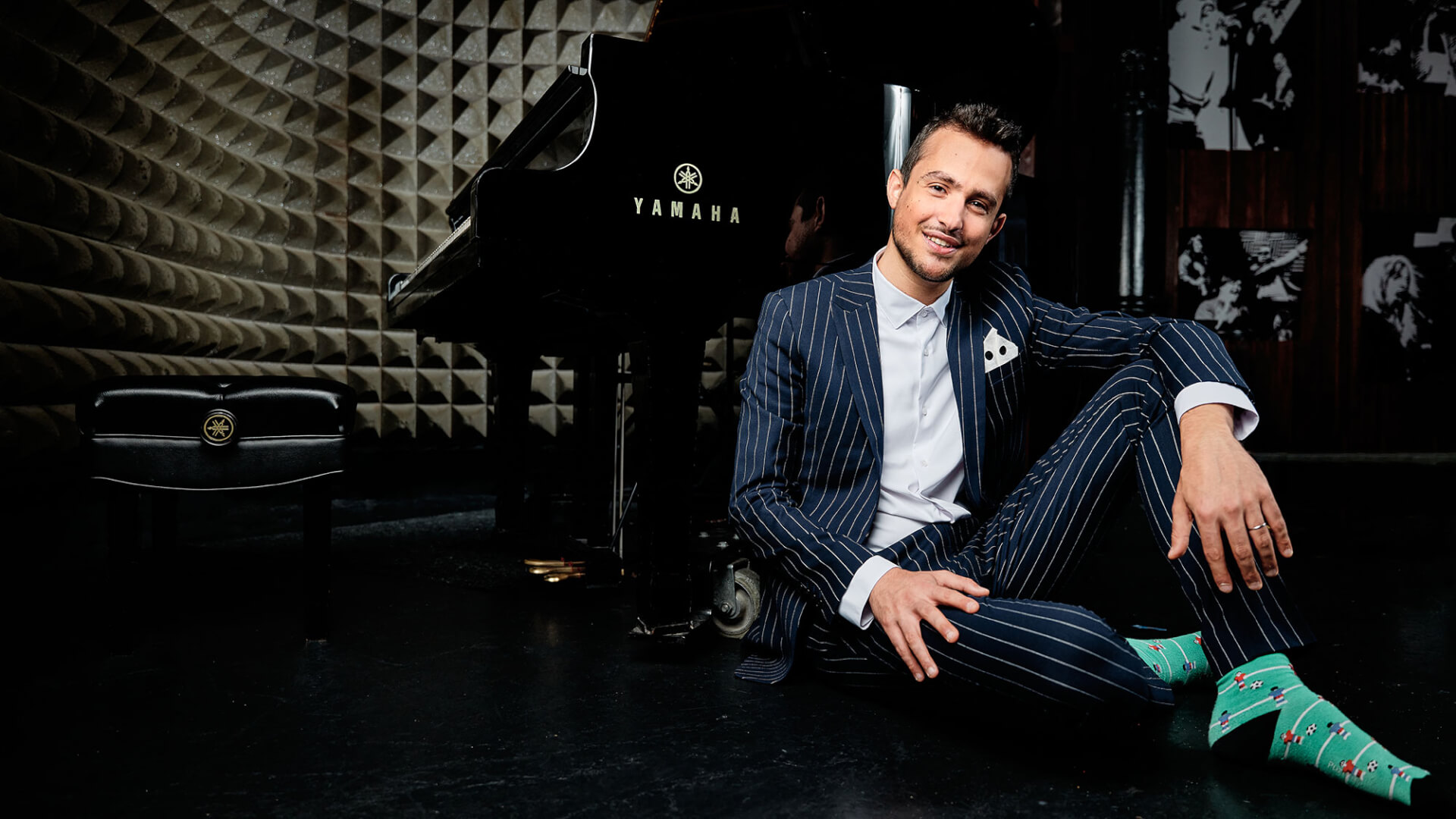 Musician wearing a pinstriped suit sitting in front of a piano