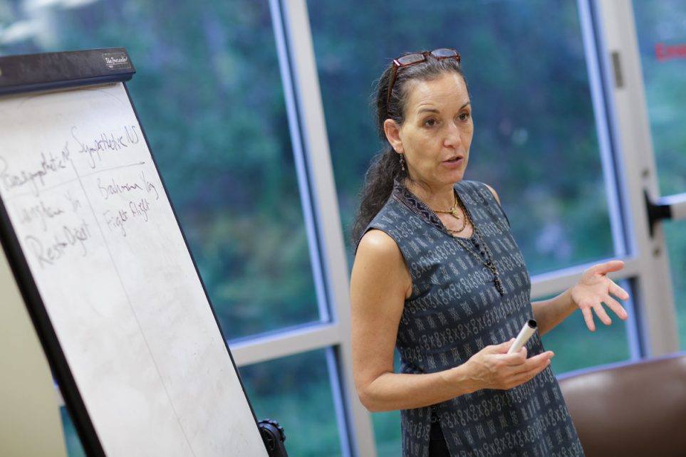 Person speaking at an educational event in front of a large pad of paper with handwritten notes