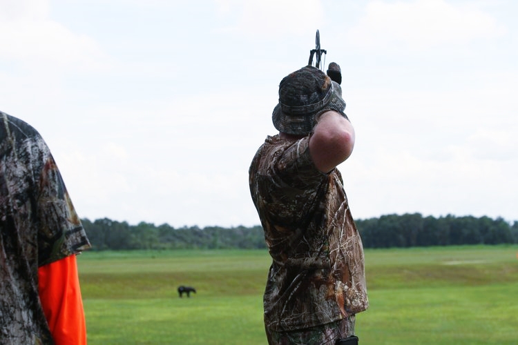 archer taking aim outdoors at a long shot