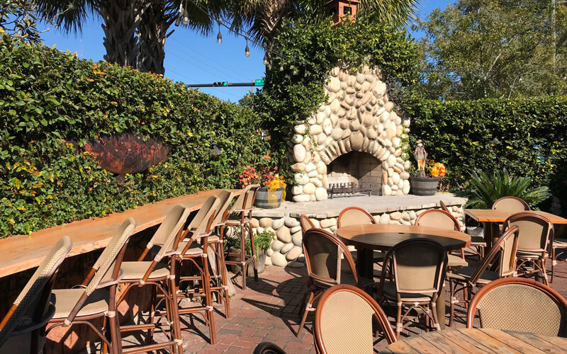 a table and chairs outside with a fireplace