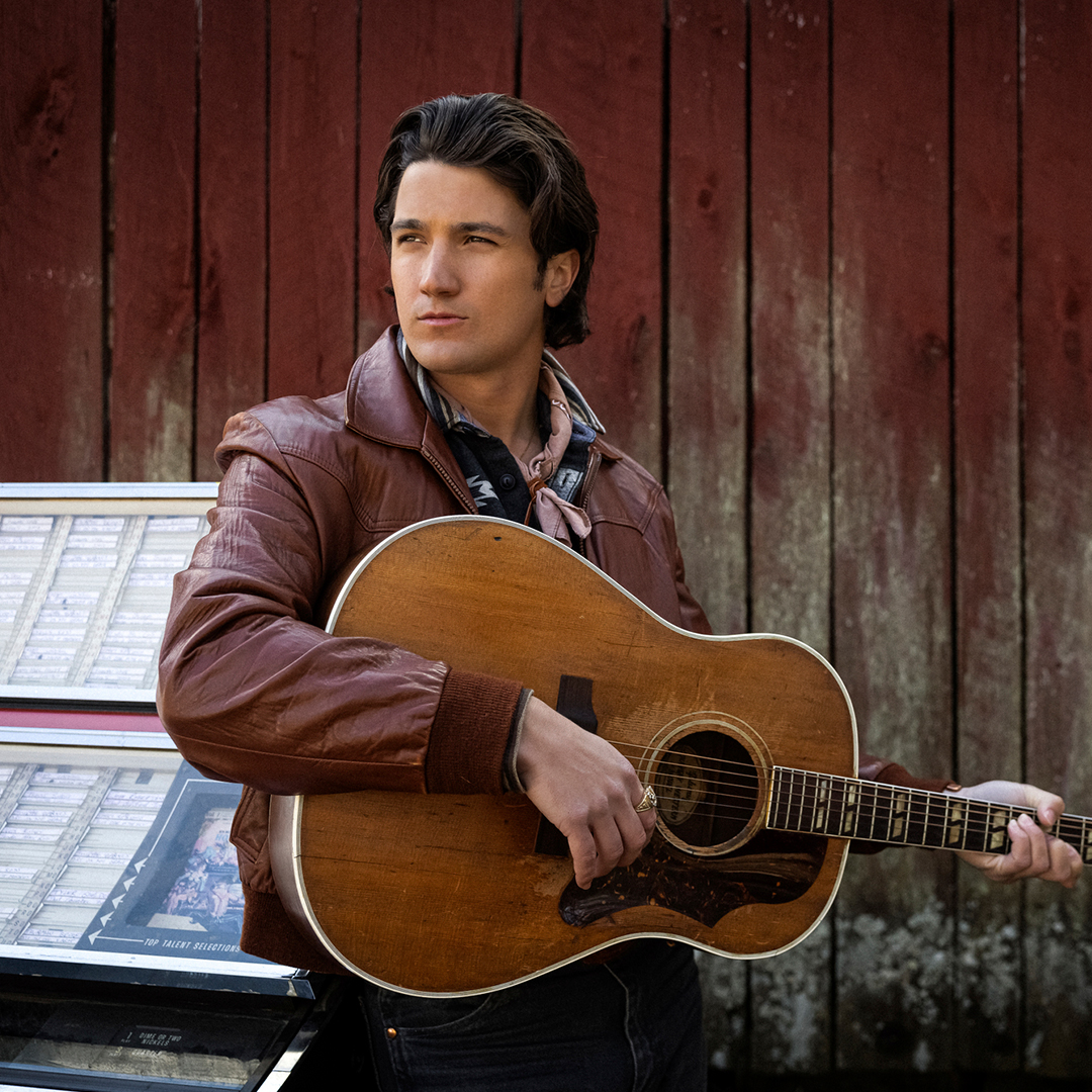 image of Drake Milligan holding a guitar