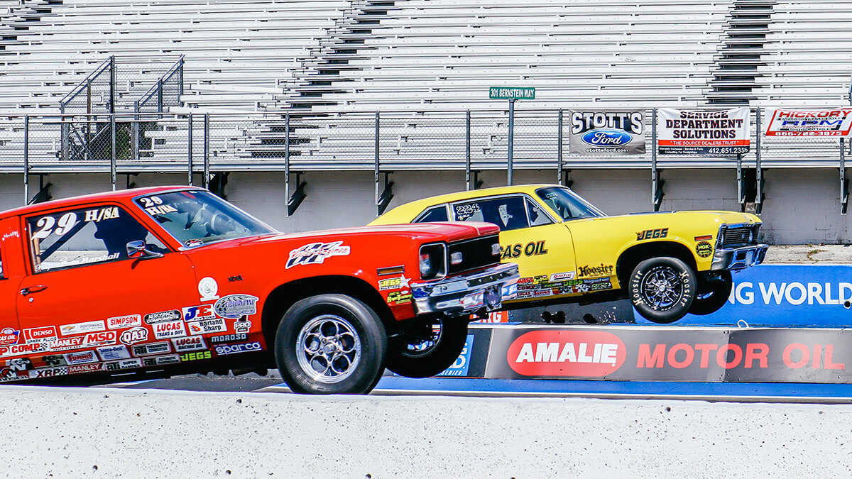 cars drag racing with front wheels in the air at gainesville raceway