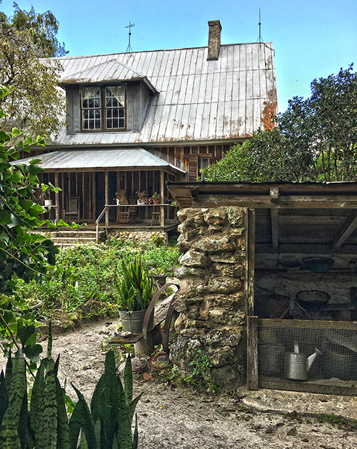 An old wooden cottage it tucked behind greenery in Alachua County, Florida. 